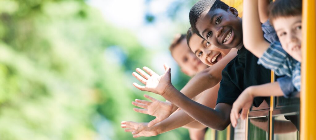 A group of children waving from a window