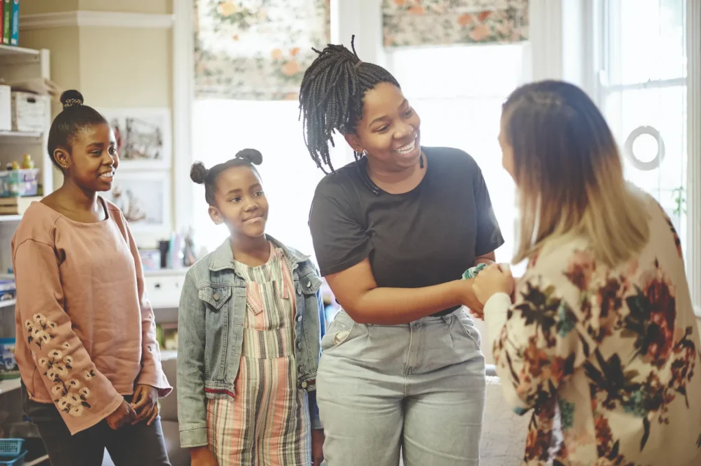A parent meeting a teacher in a classroom