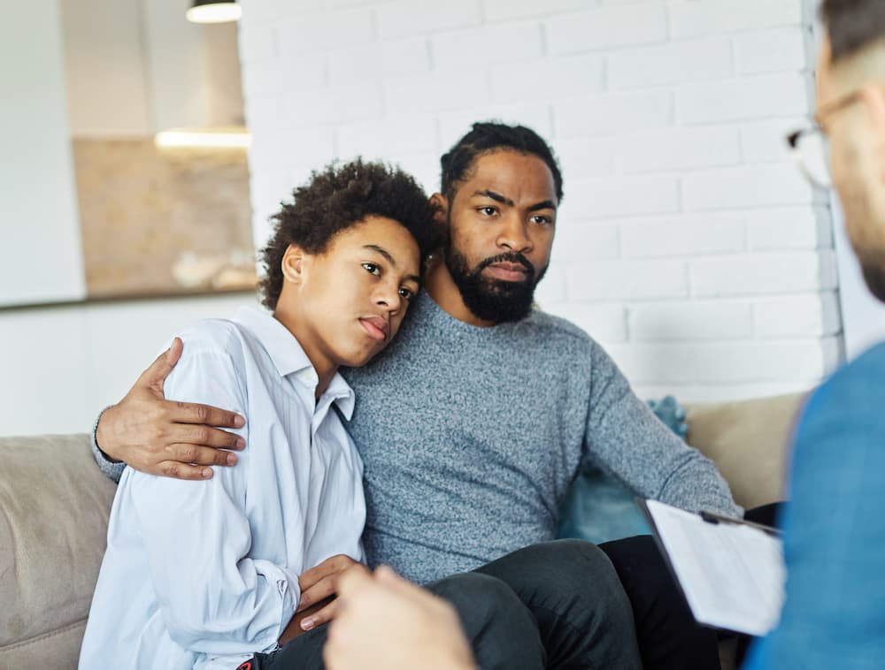 A therapist talking to a father and son